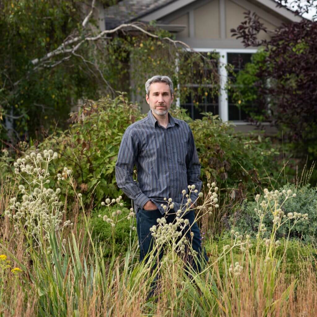 author and garden designer benjamin vogt posing in a garden he designed